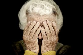 Closeup portrait depressed old woman covering her face with hand