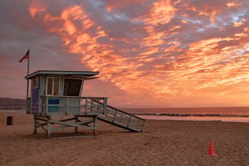 Lifeguard station with american flag on Hermosa beach at sunset